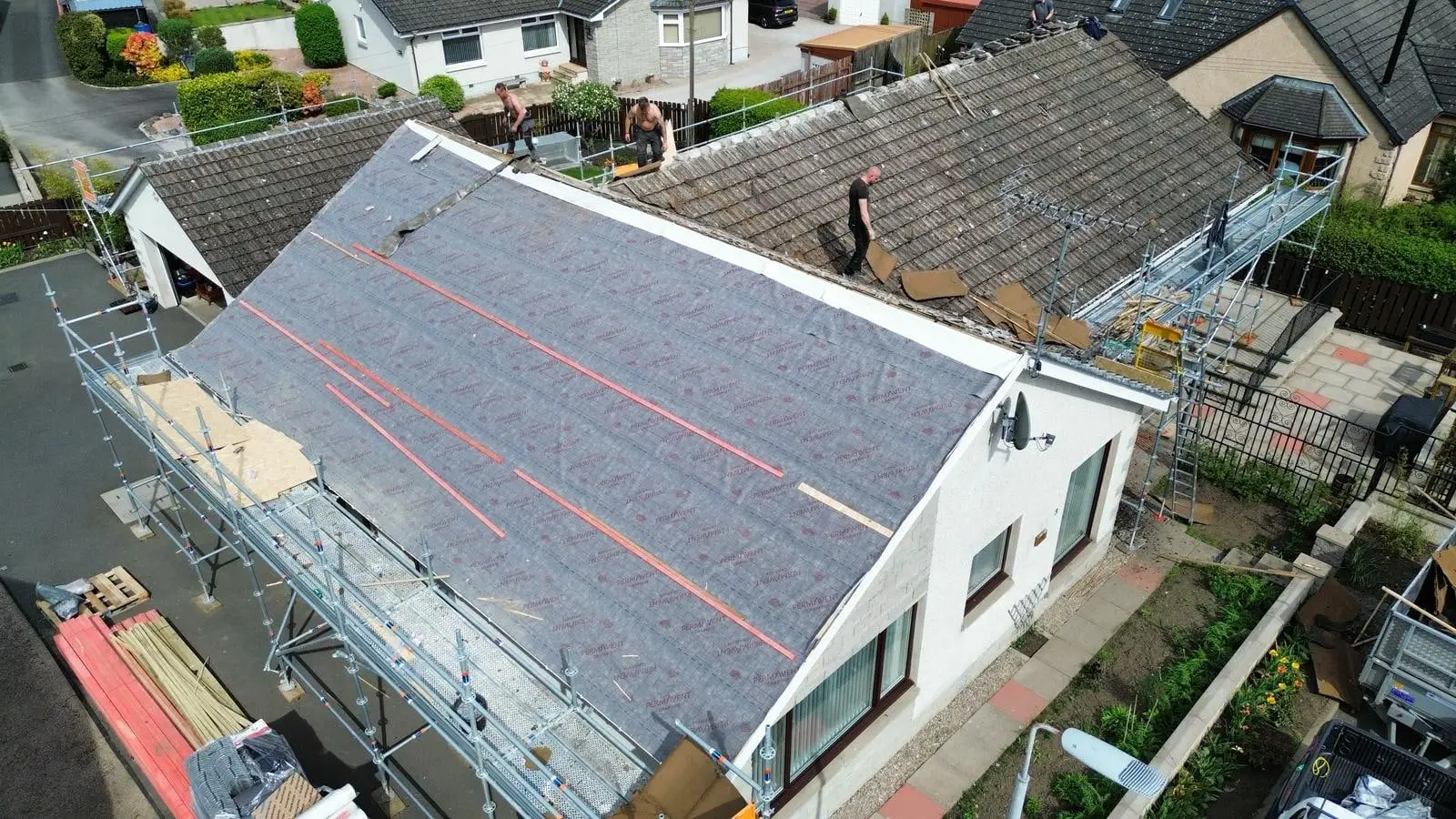 The bungalow roof covered in new membrane, seen from the end of the house