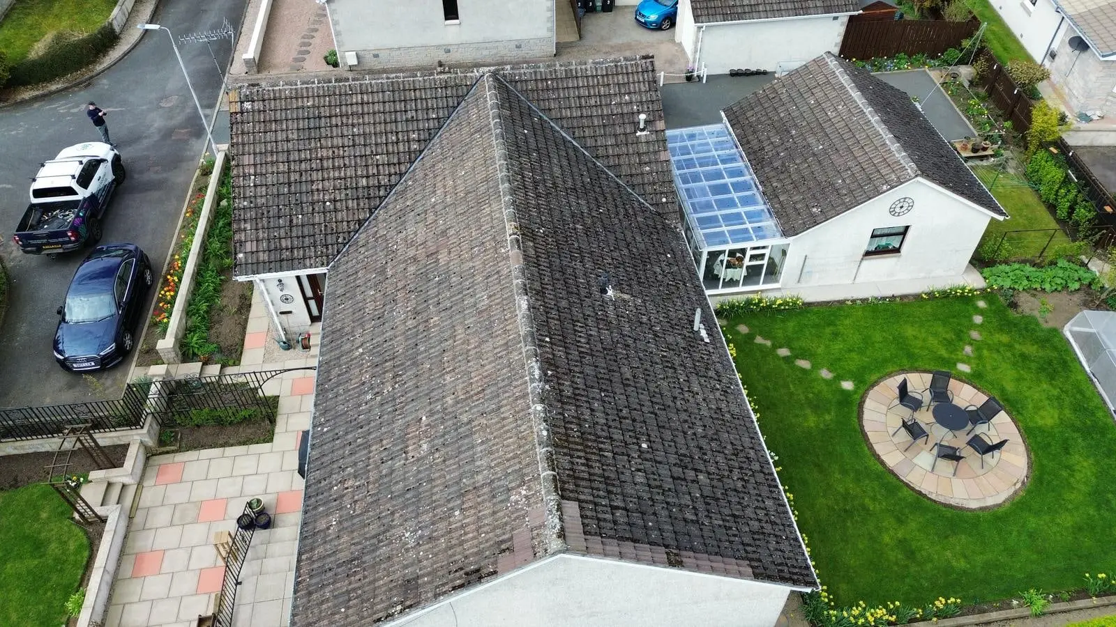 Aerial view of an L-shaped bungalow with its old concrete tiled roof