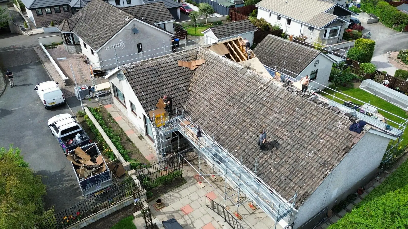 Roofers stripping the main roof of the bungalow