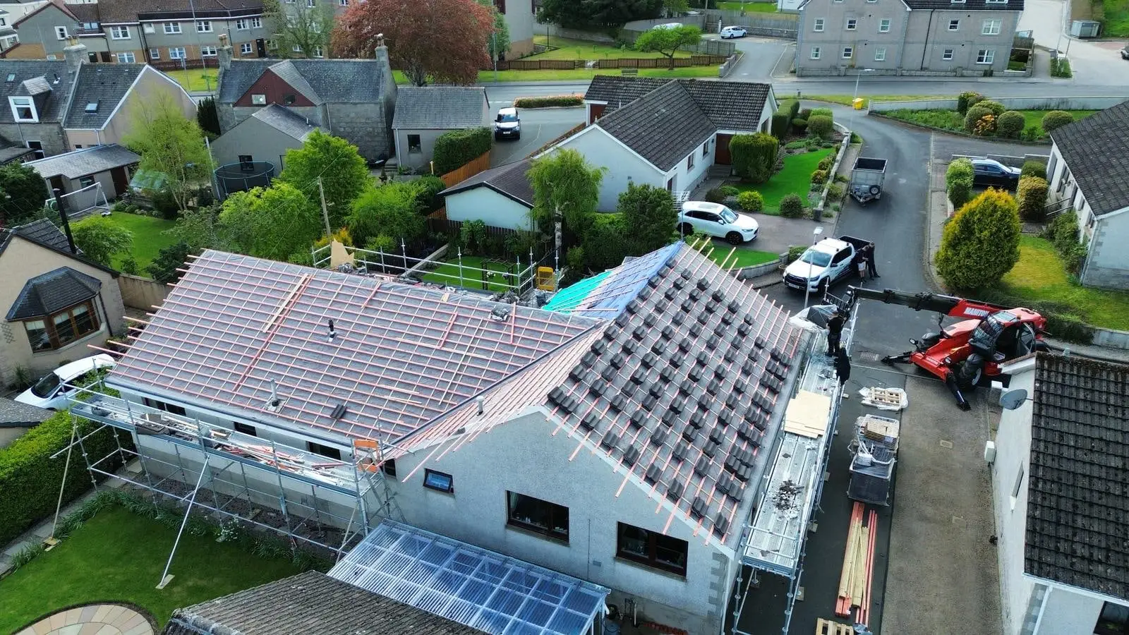 New tiles going on the bungalow roof, with a crane beside the house
