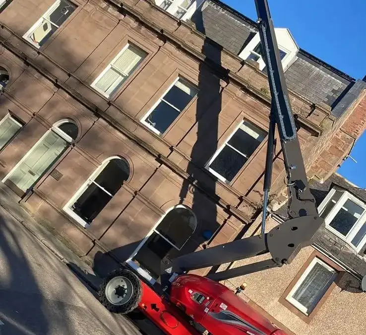 A cherry picker raised beside a sandstone tenement