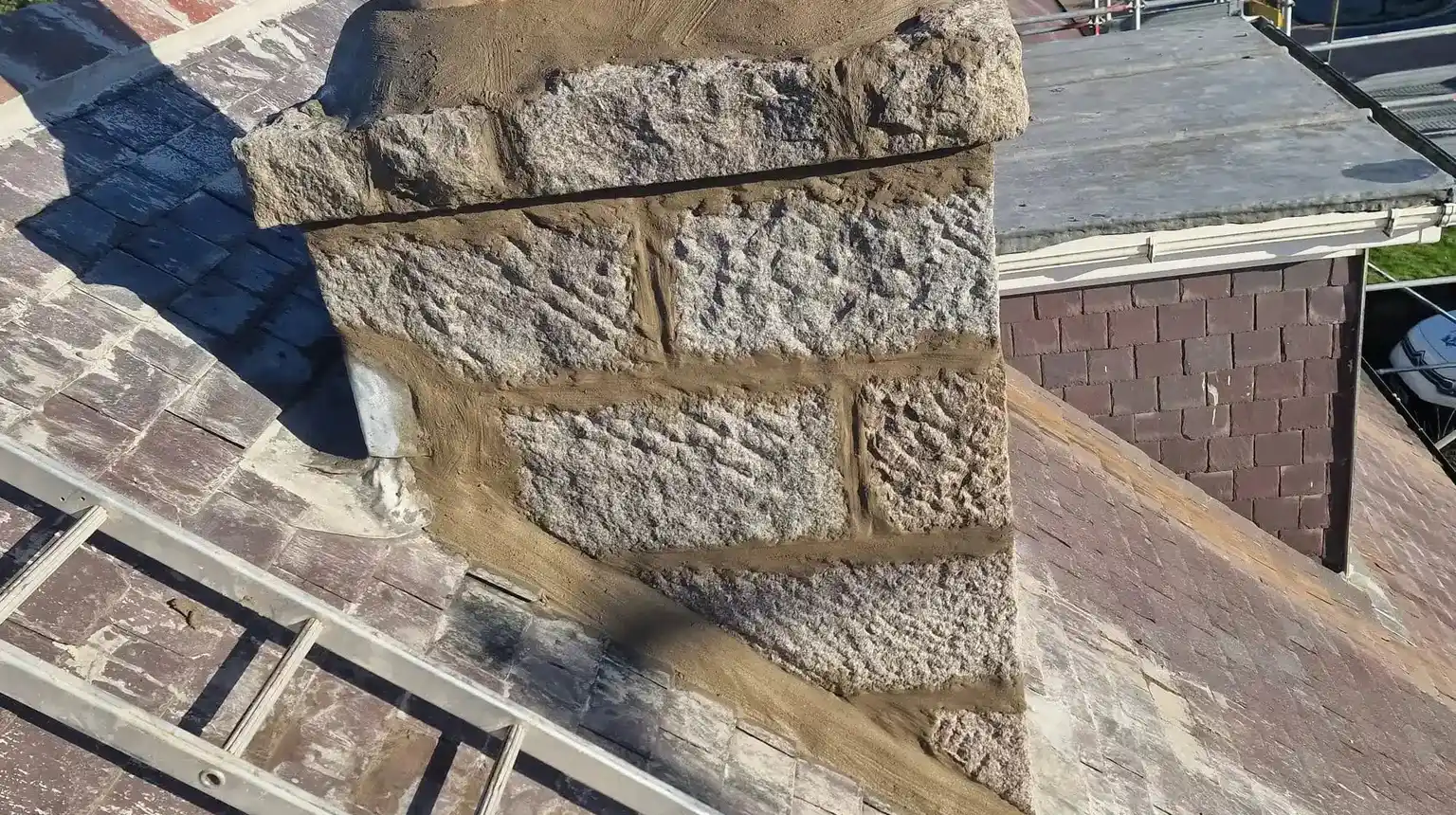 A granite chimney stack with fresh pointing and new flaunching around the pots