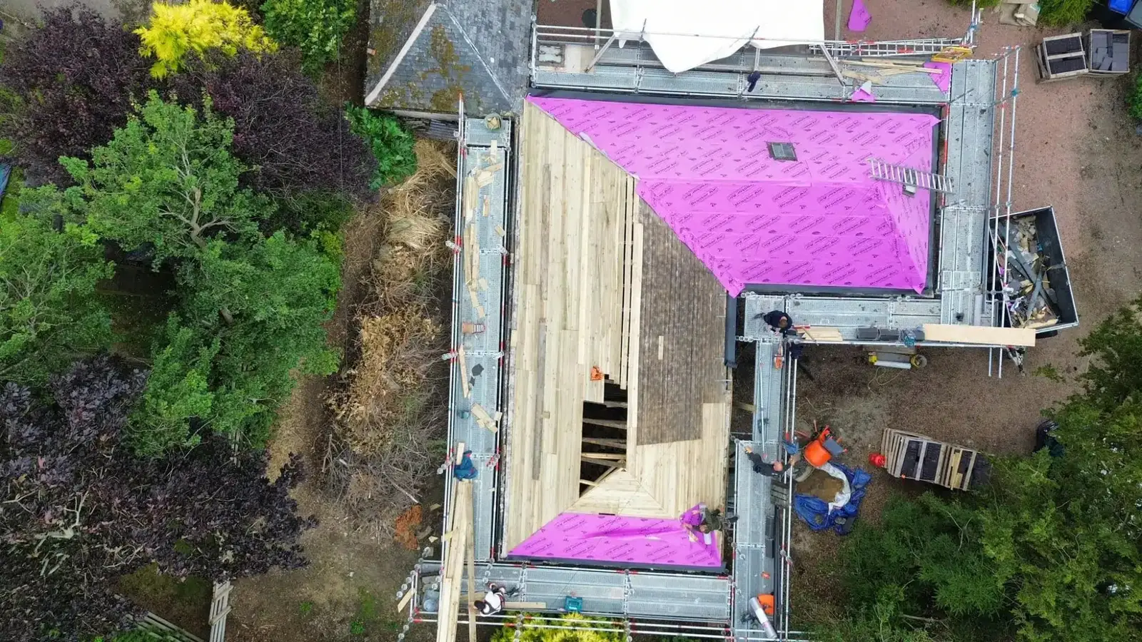 Aerial view of the roof stripped, boarded and covered in pink membrane