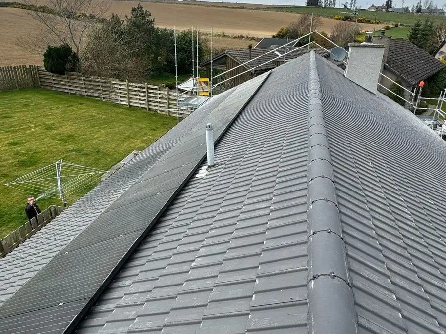 Newly re-tiled grey roof with a dry-fixed ridge and fields beyond