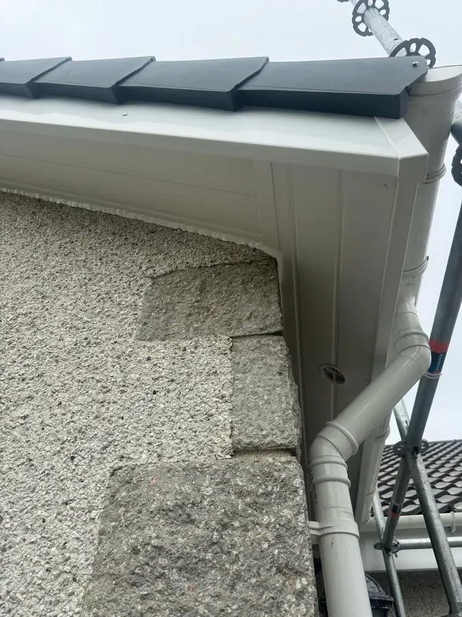 A new gutter outlet and downpipe at the corner of the house