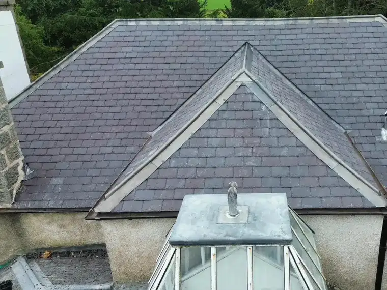 Lead-covered hips on a slate roof meeting above a glass roof lantern